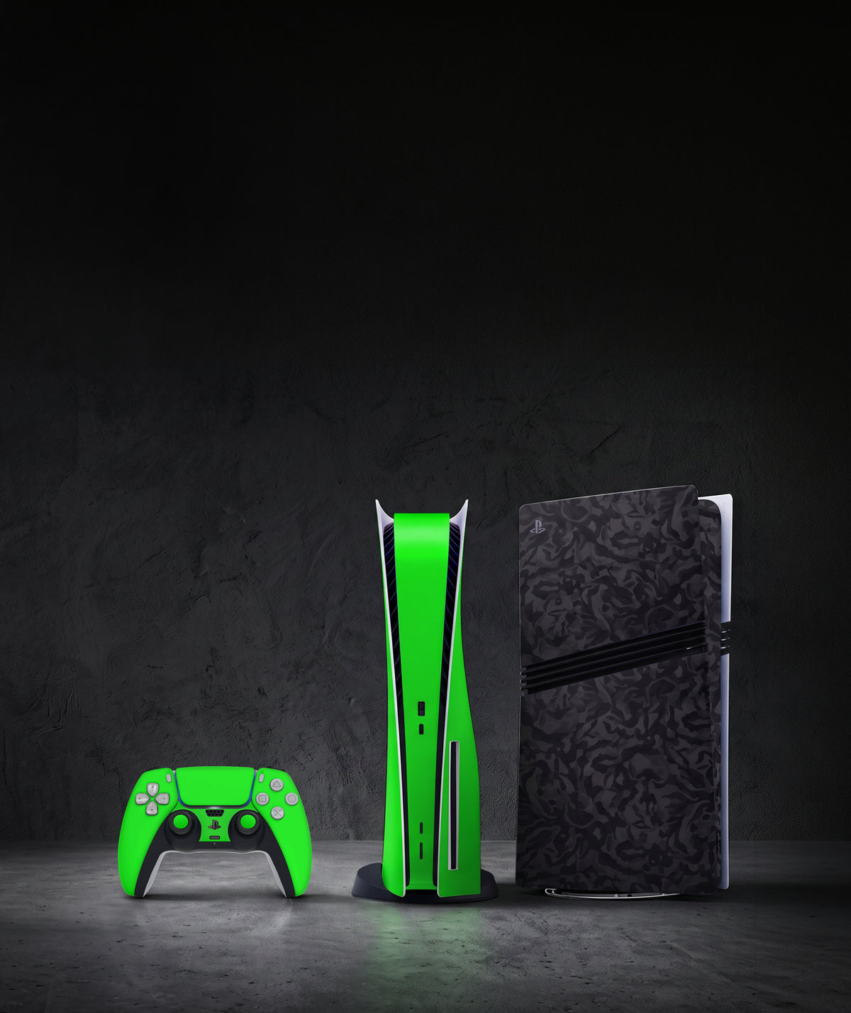 PS5 consoles arranged on a dark wooden table in low light, featuring different vinyl skin designs, including a black skin, a patterned skin, and a light gray skin. The console details and skin patterns are clearly visible.