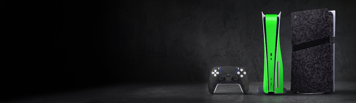 PS5 consoles arranged on a dark wooden table in low light, featuring different vinyl skin designs, including a black skin, a patterned skin, and a light gray skin. The console details and skin patterns are clearly visible.